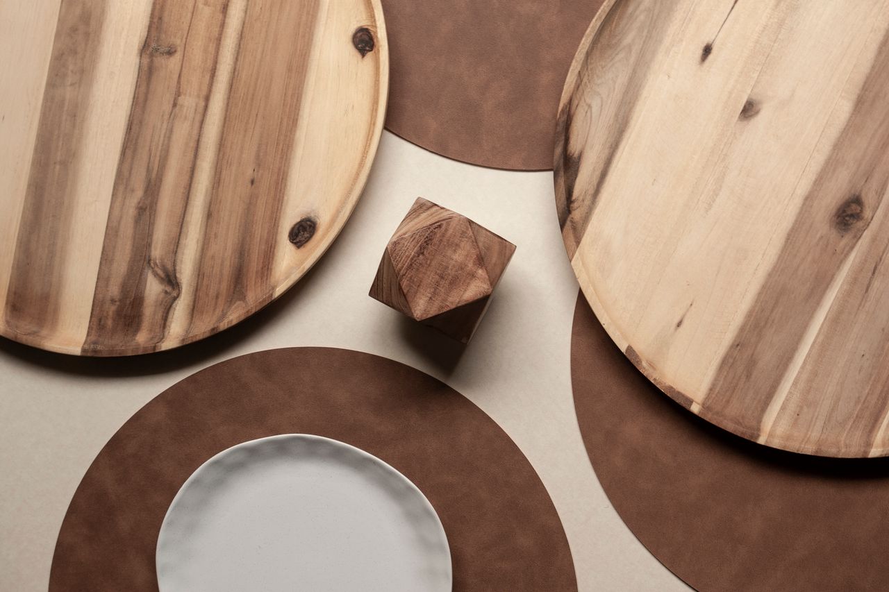 services-04 A collection of handcrafted wooden bowls displayed on monstera leaves, showcasing natural rustic decor.
